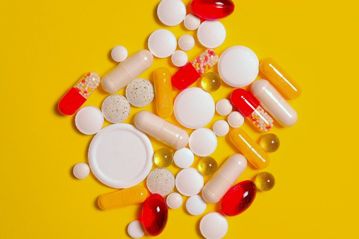 Diversi medicinali di dimensioni disparate su un fondo giallo - foto pexels - altranotizia.it